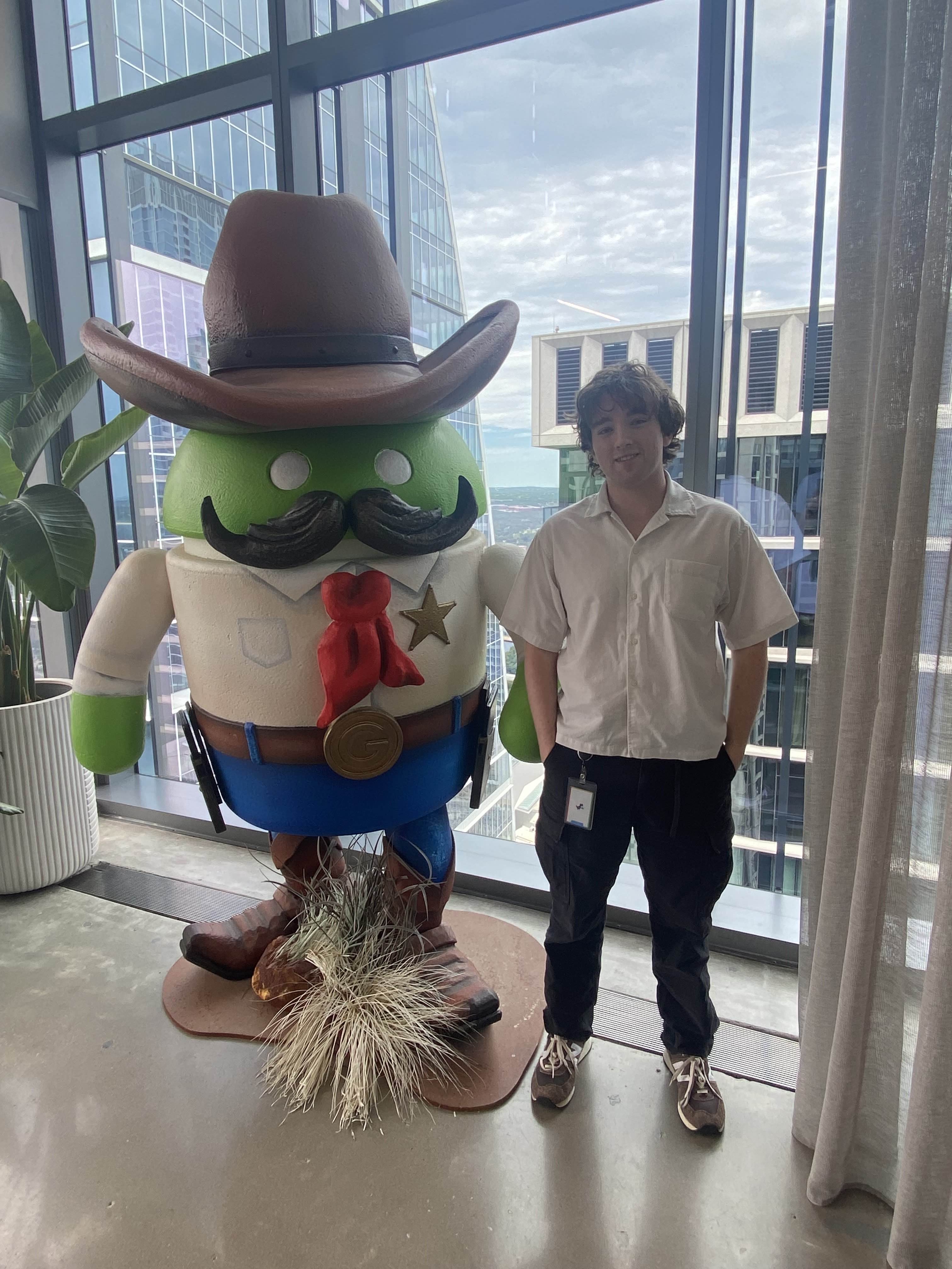 A photo of me standing next to the Google Austin android statue.